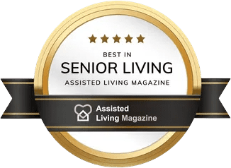 Gold and black badge with five stars reading "Best in Senior Living, Assisted Living Magazine" by Amazing Zamar, plus a heart and house icon for "Assisted Living Magazine.