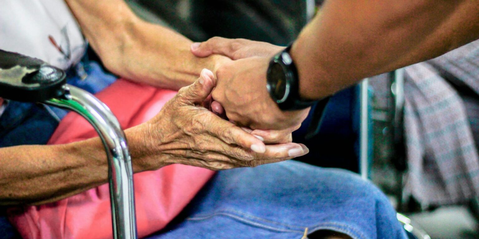 man holding hand with woman on chair